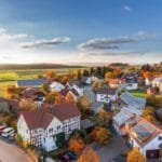 Charming aerial view of a rural village in autumn with vivid colors and clear skies.