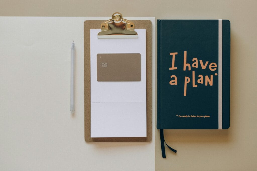 pexels-photo-8062358-8062358 A minimalist office setup featuring a planner, clipboard, card, and pen, perfect for planning and organization.